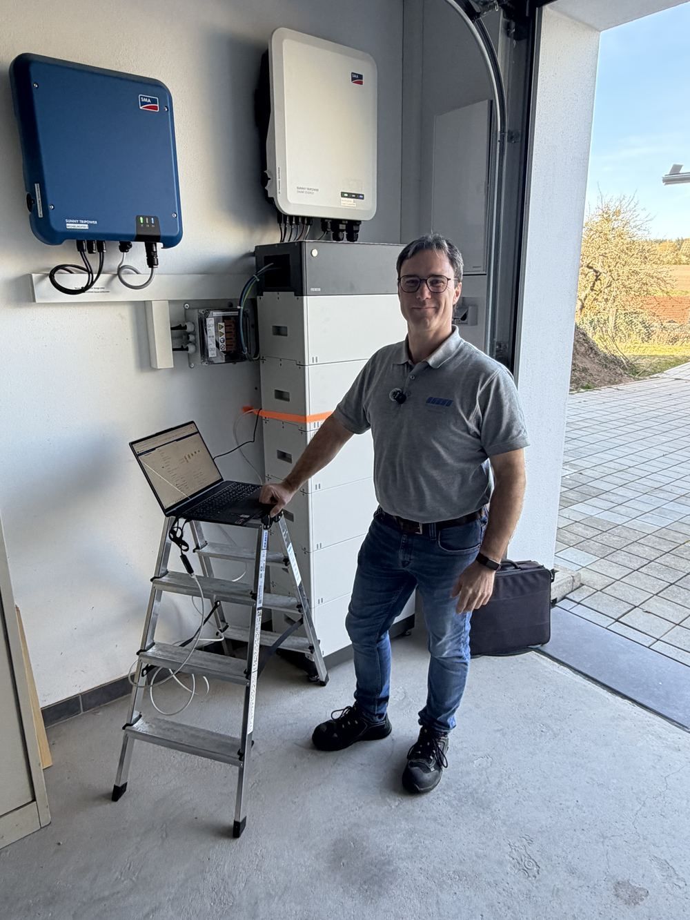 Andreas Lipphardt beim Kunden vor Wechselrichter und Speicher